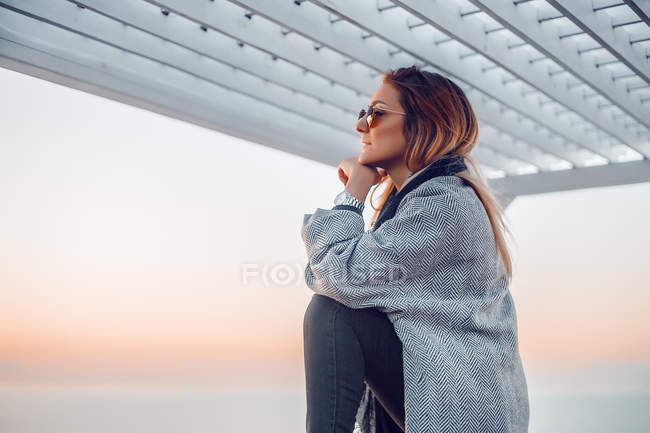 Retrato de mulher usando óculos de sol olhando para longe — Fotografia de Stock
