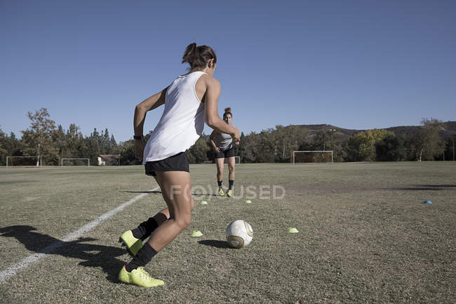 Dos mujeres jugando al fútbol en el campo de fútbol - foto de stock