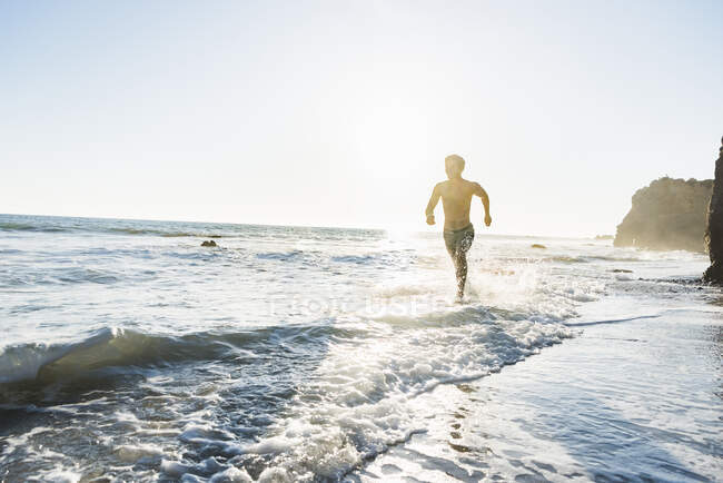 Uomo che corre su El Matador Beach, Malibu, Stati Uniti — Foto stock