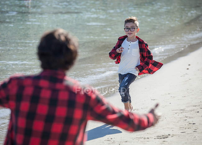 Padre e hijo en la playa, hijo corriendo hacia el padre — Papá, Vacaciones  - Stock Photo | #202475334