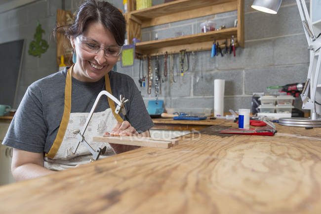 Усміхнене жіночий ювелір працювати в майстерні — стокове фото