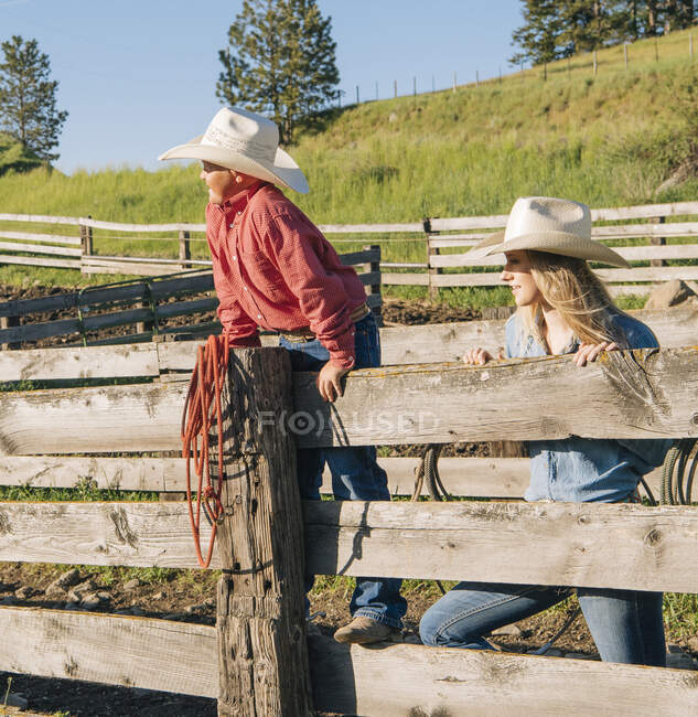 Cowboy und Cowgirl mit Cowboyhut lehnen am Zaun, schauen weg, Enterprise, Oregon, USA, Nordamerika — Stockfoto