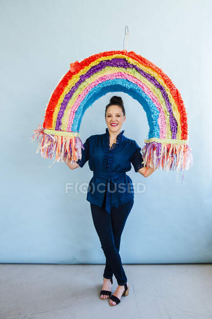 Mulher segurando arco-íris pinata — Fotografia de Stock