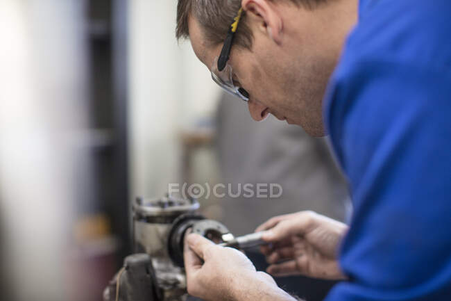 Mecánico de coche masculino trabajando en garaje de reparación - foto de stock
