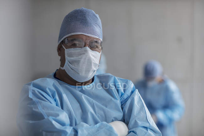 Retrato de cirurgião masculino vestindo esfregaços e máscara cirúrgica — Fotografia de Stock