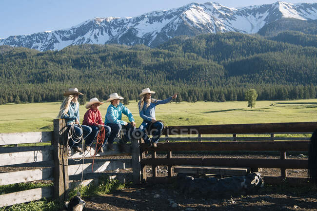 Cowboys and cowgirls on fence, looking away, Enterprise, Oregon, Stati Uniti, Nord America — Foto stock