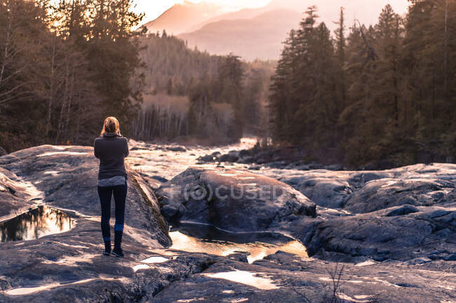 Mujer joven al aire libre, mirando el entorno rural, vista trasera, Isla de Vancouver, Canadá - foto de stock
