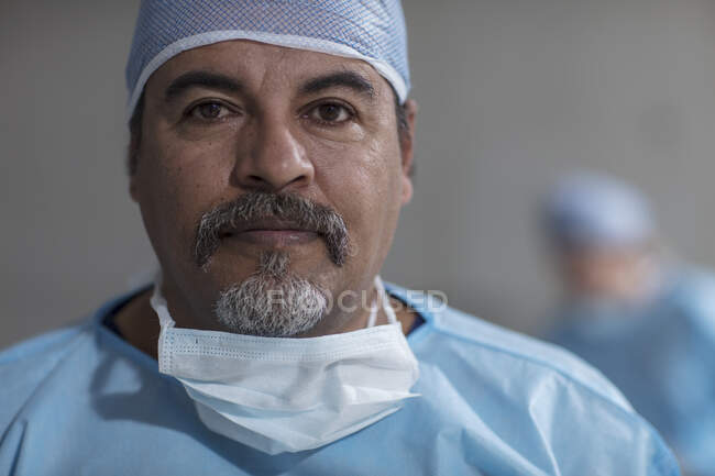 Retrato de cirurgião masculino vestindo esfregaços e máscara cirúrgica — Fotografia de Stock