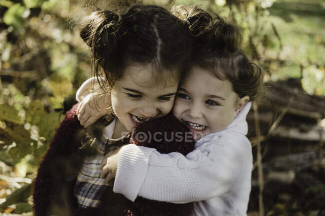 Due giovani sorelle che si abbracciano, in ambiente rurale — Foto stock