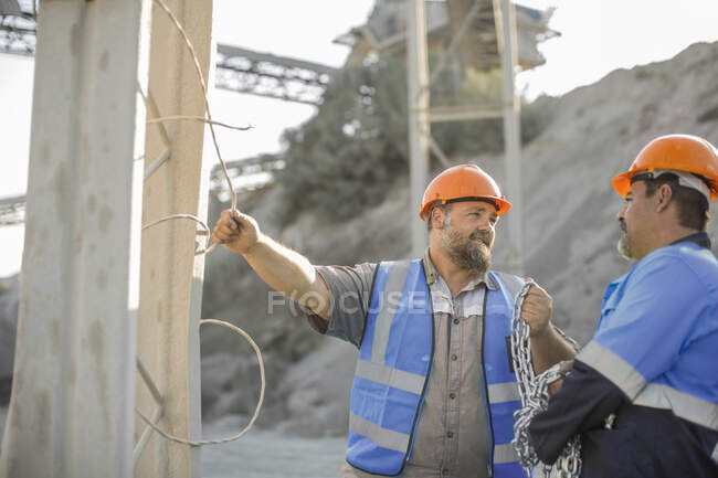 Two quarry workers in quarry, having discussion — Stock Photo