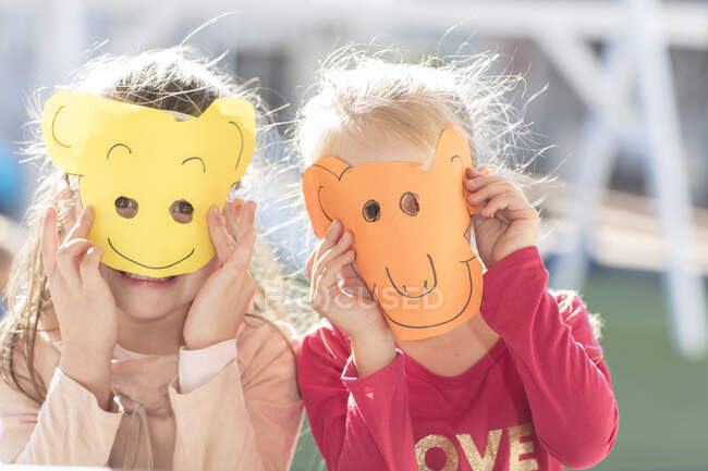 Retrato se duas crianças usando máscaras de papel — Fotografia de Stock