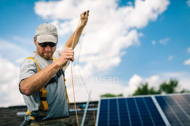 Arbeiter installiert Sonnenkollektoren auf Hausdach — Stockfoto
