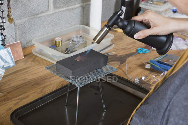 Nahaufnahme einer Juwelierin, die in einer Werkstatt mit Werkzeug arbeitet — Stockfoto