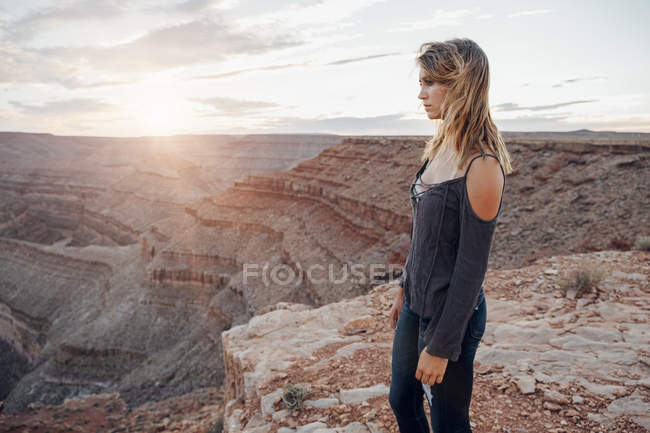 Young woman standing on cliff edge and looking at view, Mexican Hat, Utah, USA — Stock Photo