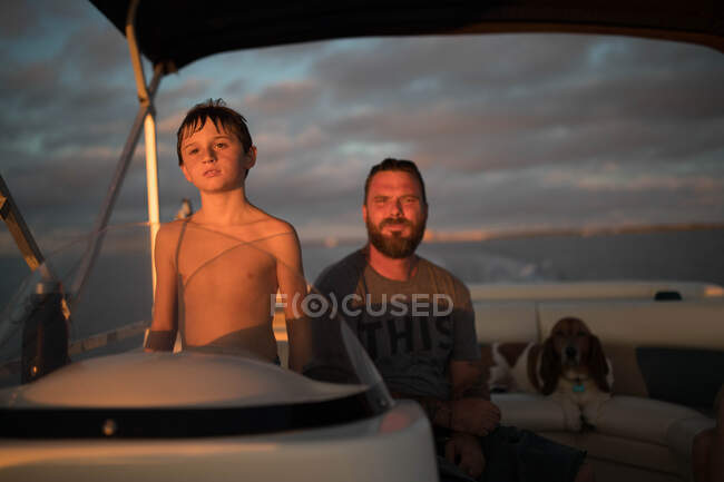 Padre e figlio in barca con cane da compagnia — Foto stock