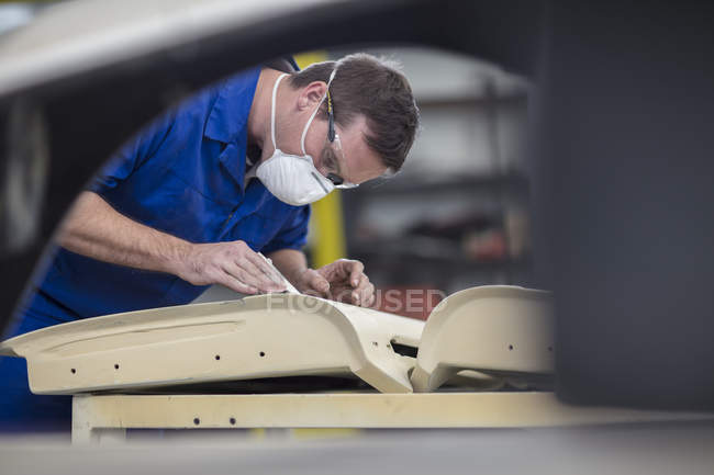 Механик шлифования двери автомобиля в ремонтном гараже — стоковое фото