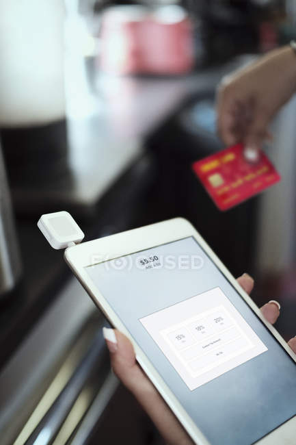 Gros plan des mains de la femme tenant tablette numérique et carte de crédit — Photo de stock