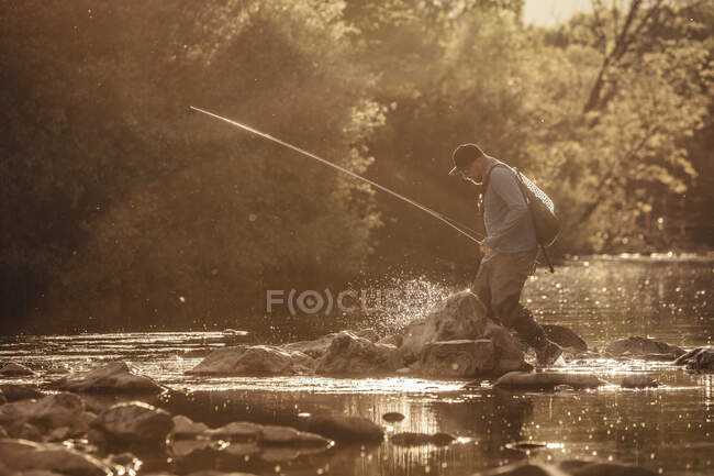 Pescador pisa tornozelo no fundo do rio iluminado pelo sol, Mozirje, Brezovica, Eslovénia — Fotografia de Stock