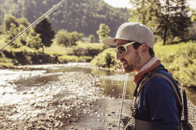 Joven pescador con caña de pescar por río, Mozirje, Brezovica, Eslovenia - foto de stock