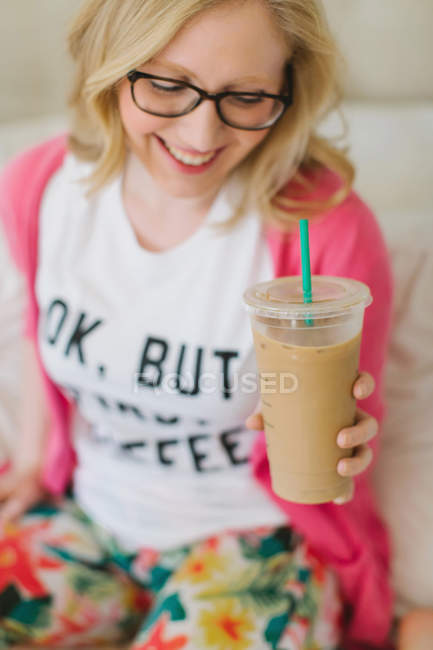 Jovem mulher em casa com xícara de café takeaway — Fotografia de Stock