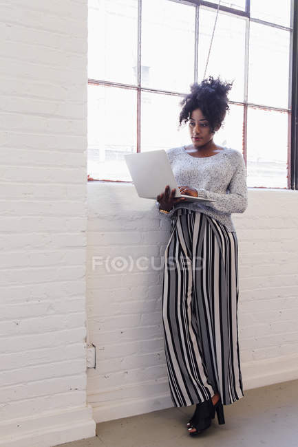 Woman in industrial office building using laptop — Stock Photo