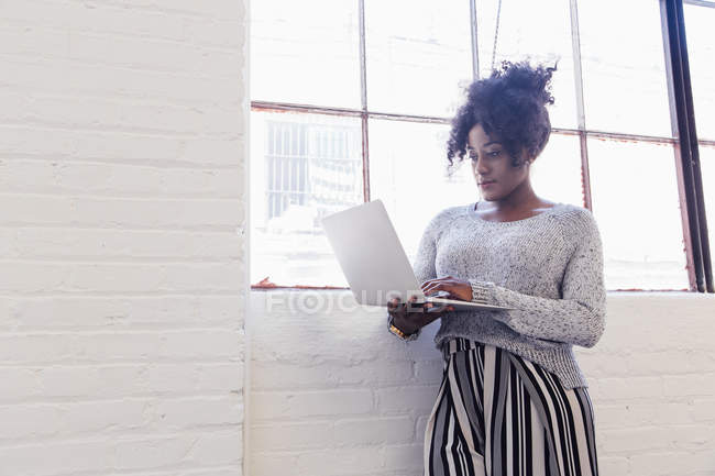 Donna in edificio per uffici industriale con computer portatile — Foto stock