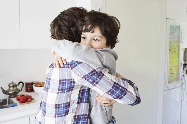 Mutter und Sohn zu Hause, umarmen sich — Stockfoto