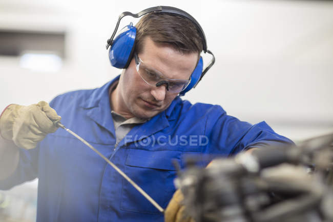 Mécanicien de voiture huile de contrôle dans le garage de réparation — Photo de stock