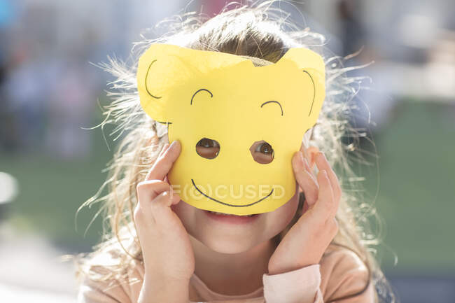 Portrait of girl wearing paper mask — Stock Photo