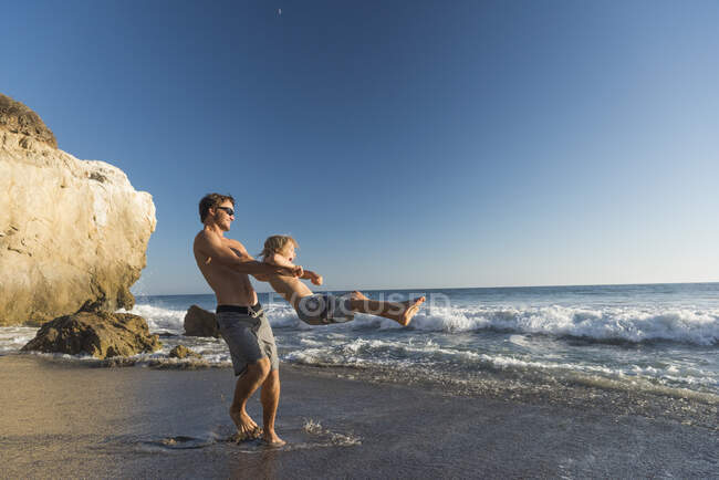 Brüder spielen am Strand von El Matador, Malibu, USA — Stockfoto