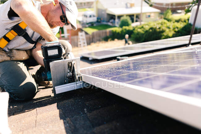 Workman installing solar panels on roof of house, close-up — Stock Photo