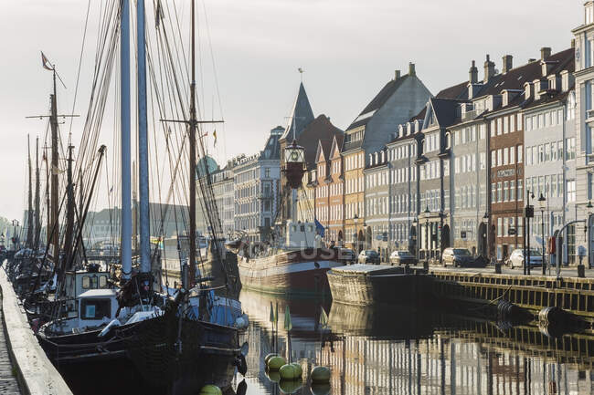 Amarran veleros y casas del siglo XVII en el canal de Nyhavn, Copenhague, Dinamarca - foto de stock