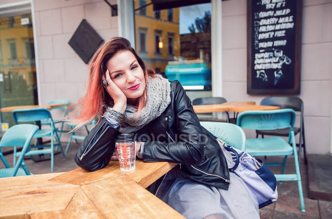Жінка сидить за столом у тротуарному кафе — стокове фото