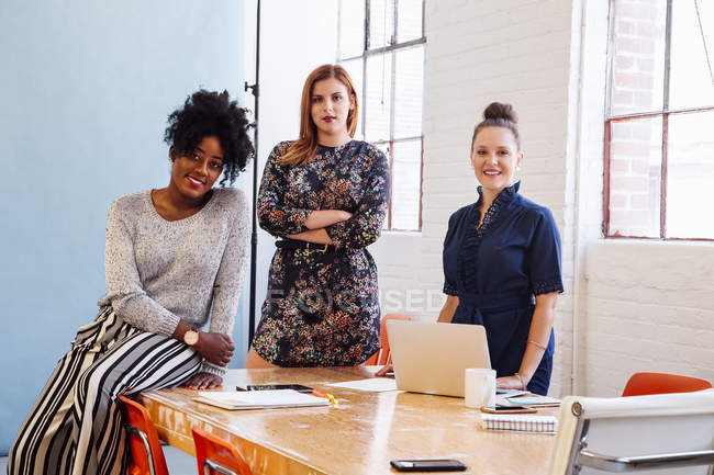 Portrait of smiling female colleagues in office, looking at camera — Stock Photo