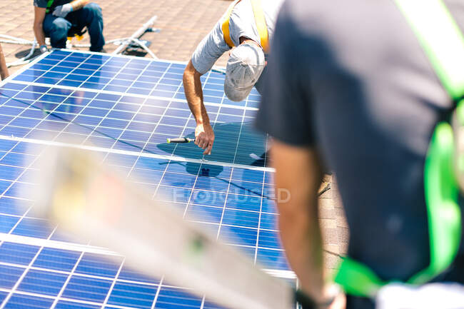 Tre operai che installano pannelli solari sul tetto della casa — Foto stock