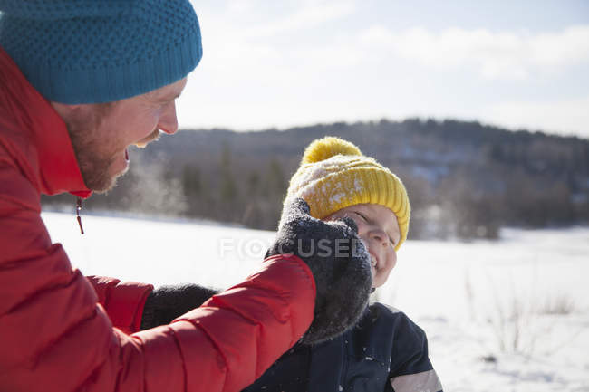 Мужчина и сын смеются в зимнем пейзаже — стоковое фото