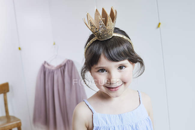 Portrait of smiling young girl wearing crown headband — Stock Photo