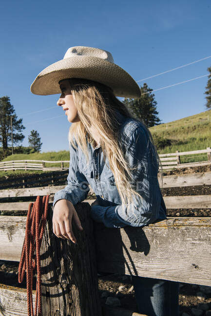 Cowgirl mit Cowboyhut lehnt am Zaun, schaut weg, Enterprise, Oregon, USA, Nordamerika — Stockfoto