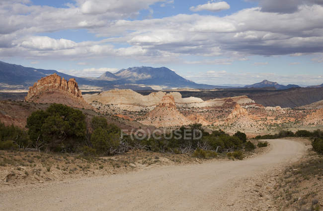 Route déserte entre les collines menant aux montagnes — Photo de stock