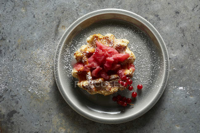 Vista superior de Waffle con mermelada de ruibarbo de fresa, grosellas rojas y azúcar en polvo - foto de stock