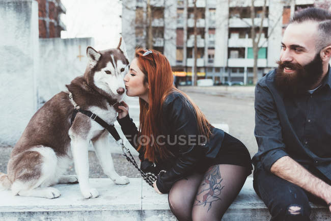 Rojo pelo mujer besos perro - foto de stock