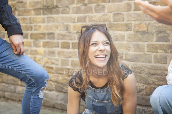 Группа молодых друзей на открытом воздухе, молодая женщина смеется — стоковое фото