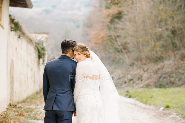 Portrait of bride and bridegroom on country lane — Stock Photo
