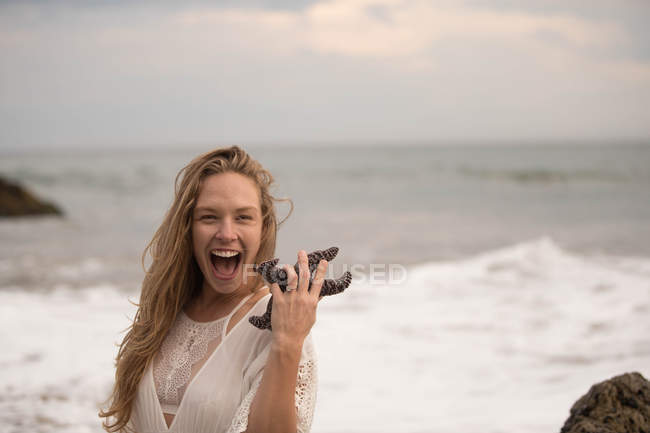 Femme tenant une étoile de mer, Malibu, Californie, États-Unis — Photo de stock