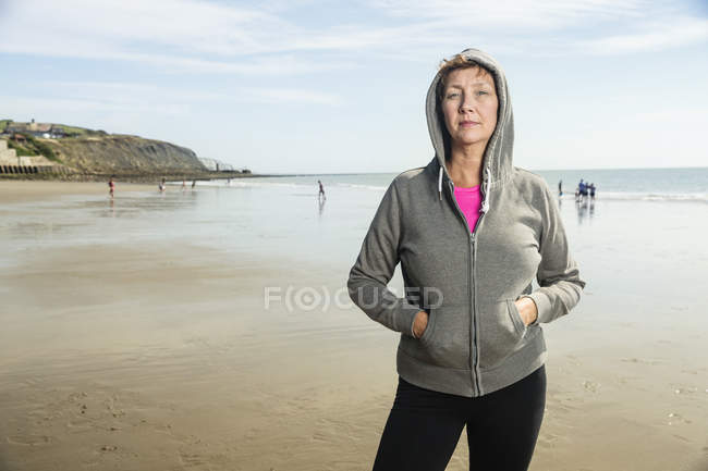 Porträt einer Frau mit Kapuzenpulli am Strand — Stockfoto