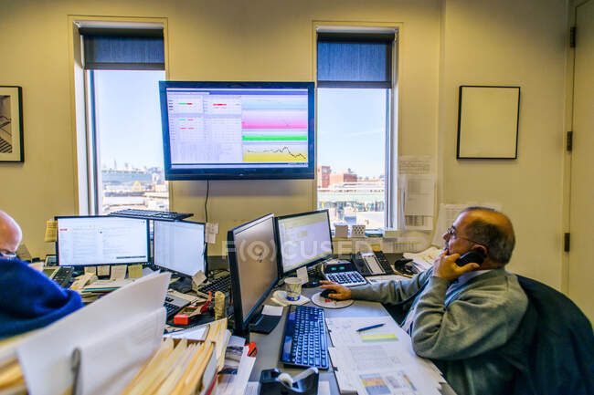 Männlicher Büroleiter telefoniert am Schreibtisch — Stockfoto