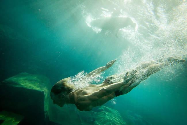 Unterwasser-Ansicht des tauchenden Mannes im Meerwasser — Stockfoto