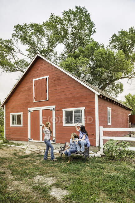 Drei junge Frauen High Fiving außerhalb Ranch Bauernhaus, Bridger, Montana, USA — Stockfoto