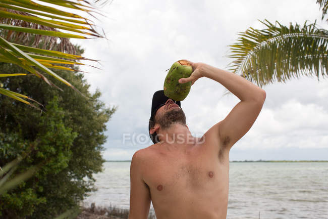 Mann löscht Durst mit Kokosmilch — Stockfoto