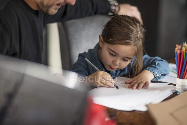 Jovem e sua filha desenho à mesa — Fotografia de Stock